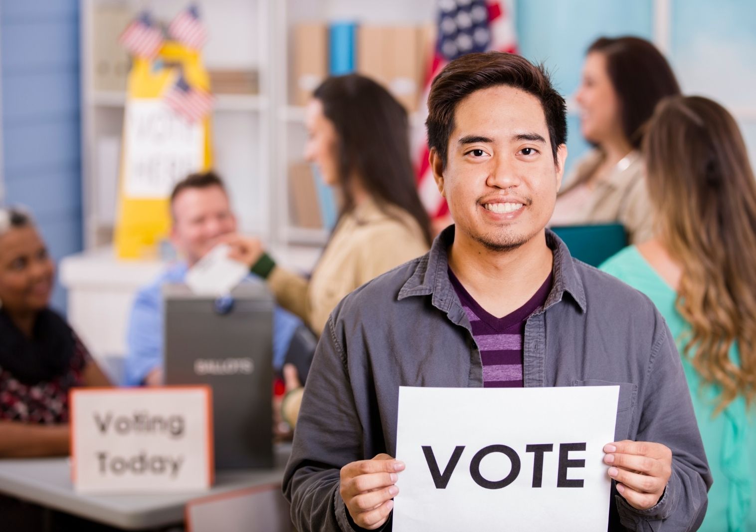 Asian male holding a vote sign